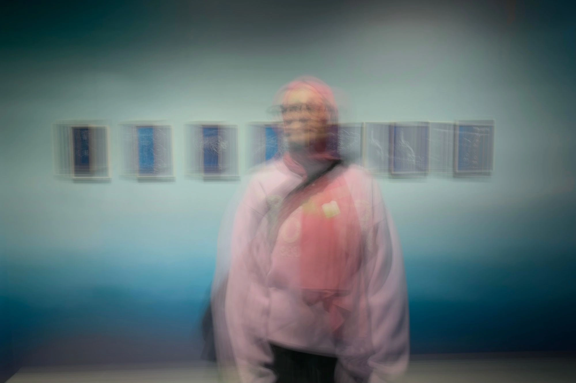 2026-03-28 - i16 - color - NL - Rotterdam - Blurry person in front of all of cyanotype prints