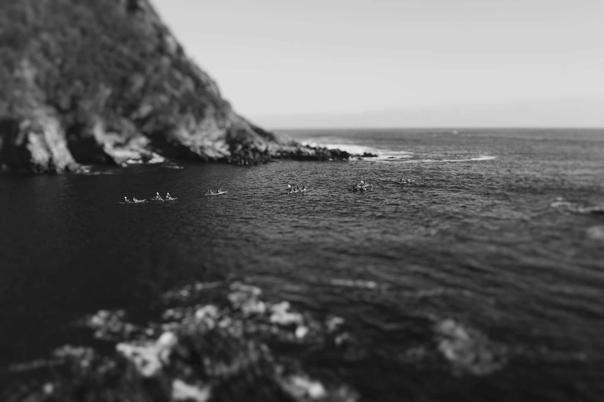 2018-12-24 - n18-55 - bw - ZA - Tsitsikamma - Kayaks in a row between mountains, rowing into the ocean