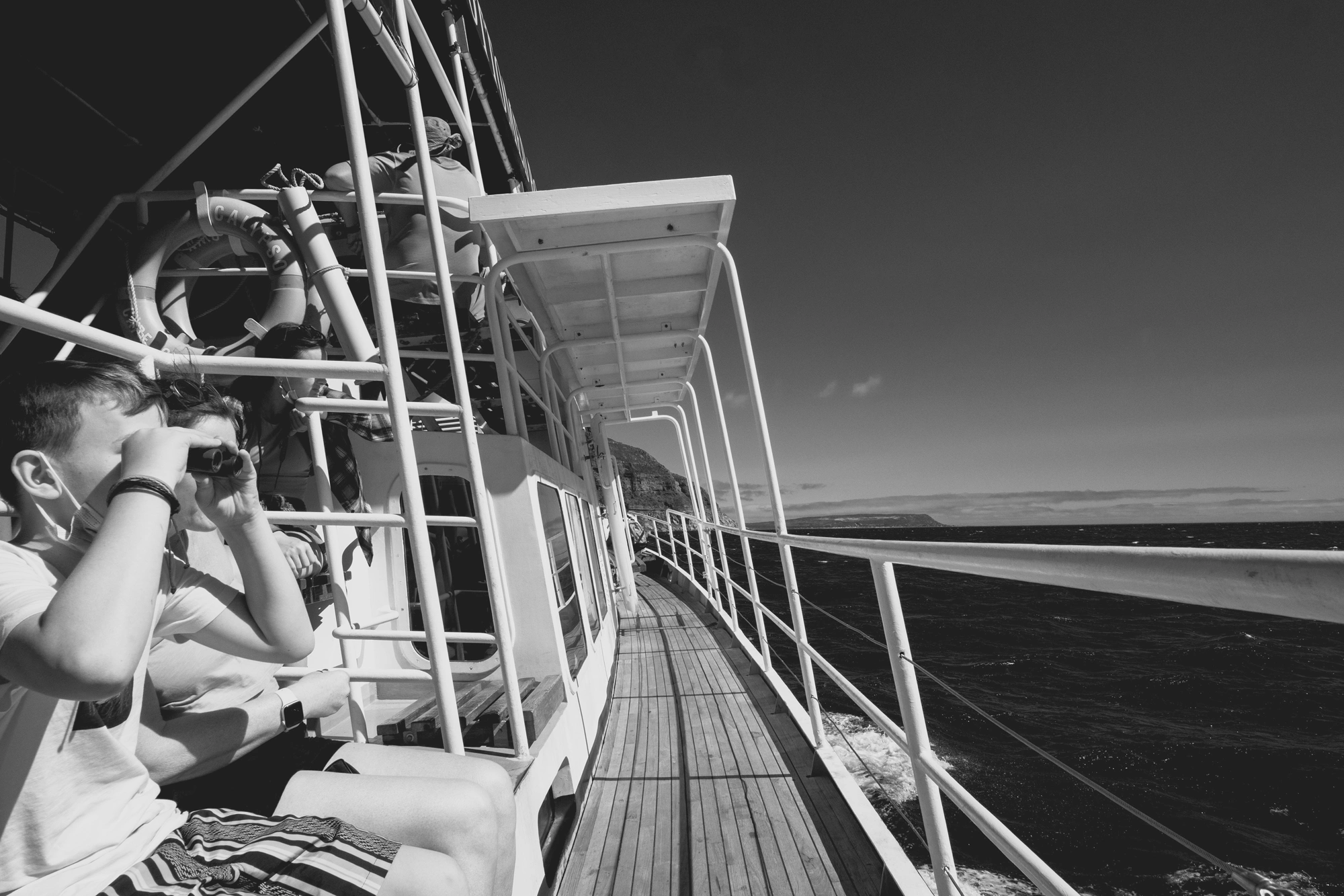 2022-02-13 - xt15-45 - bw - ZA - Cape Town - People looking over the railing of a boat into the ocean