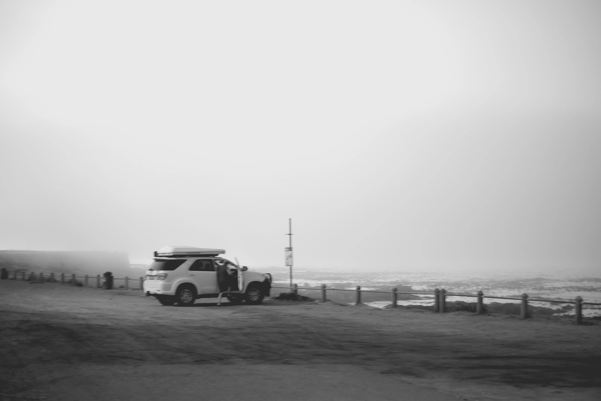2022-02-15 - xt35 - bw - ZA - Cape Town - Car parked beside beach on misty day