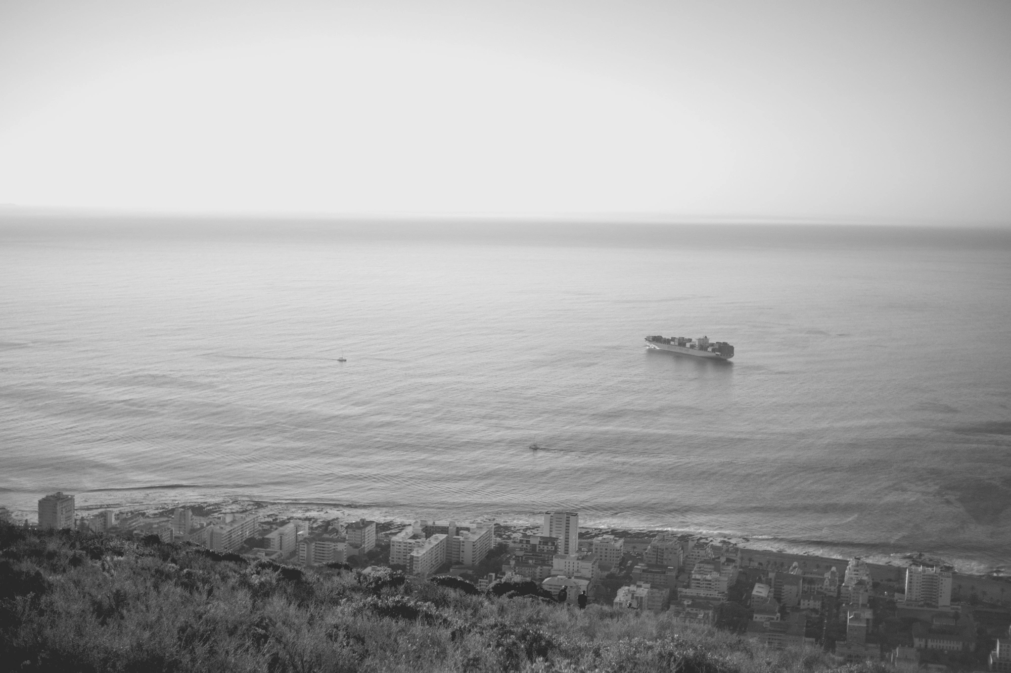 2022-02-16 - xt35 - bw - ZA - Cape Town - Buildings with cargo ship in the distance