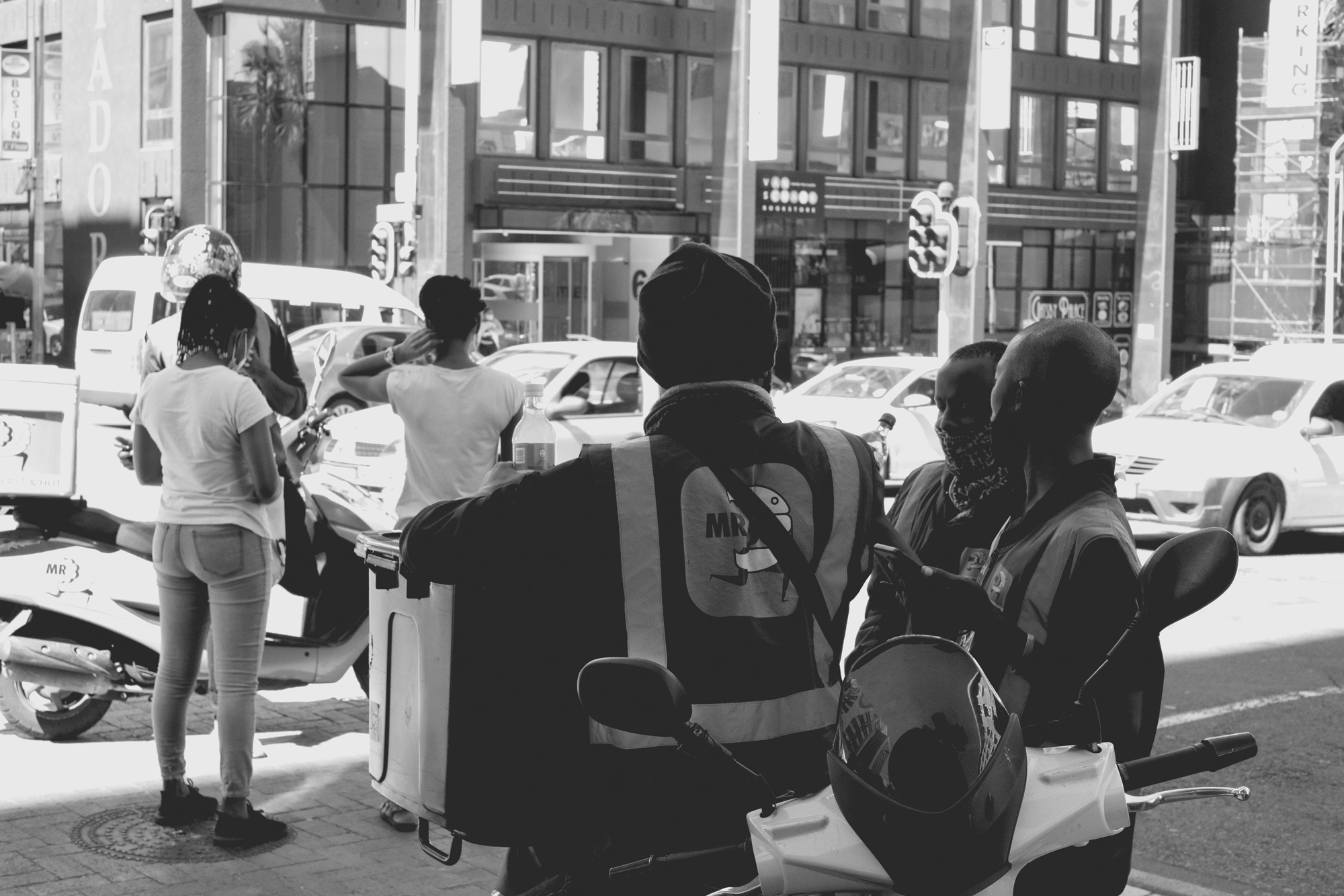2022-02-16 - xt35 - bw - ZA - Cape Town - Delivery drivers standing next to motorbikes