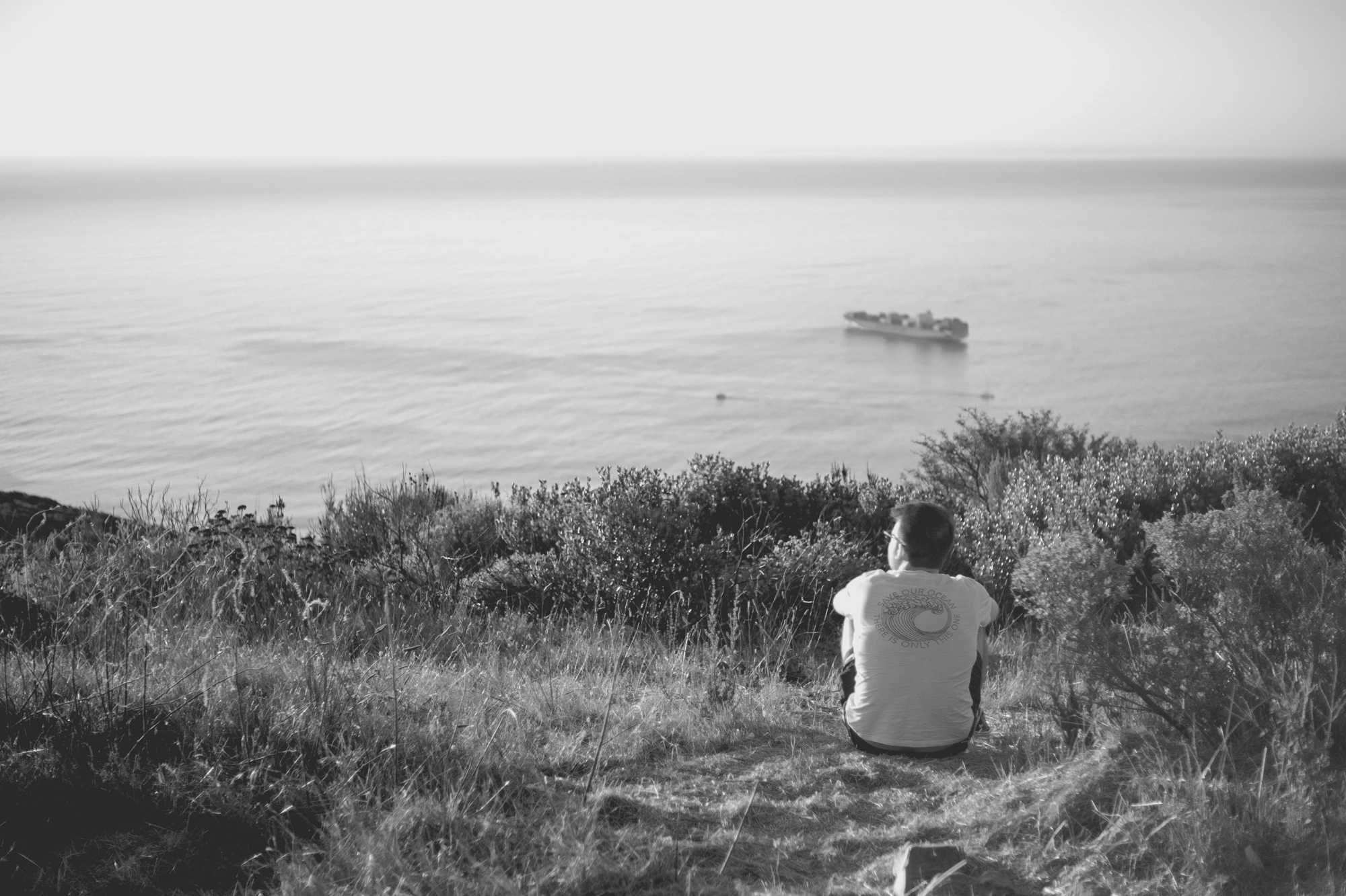 2022-02-17 - xt35 - bw - ZA - Cape Town - Man sitting over view of ocean