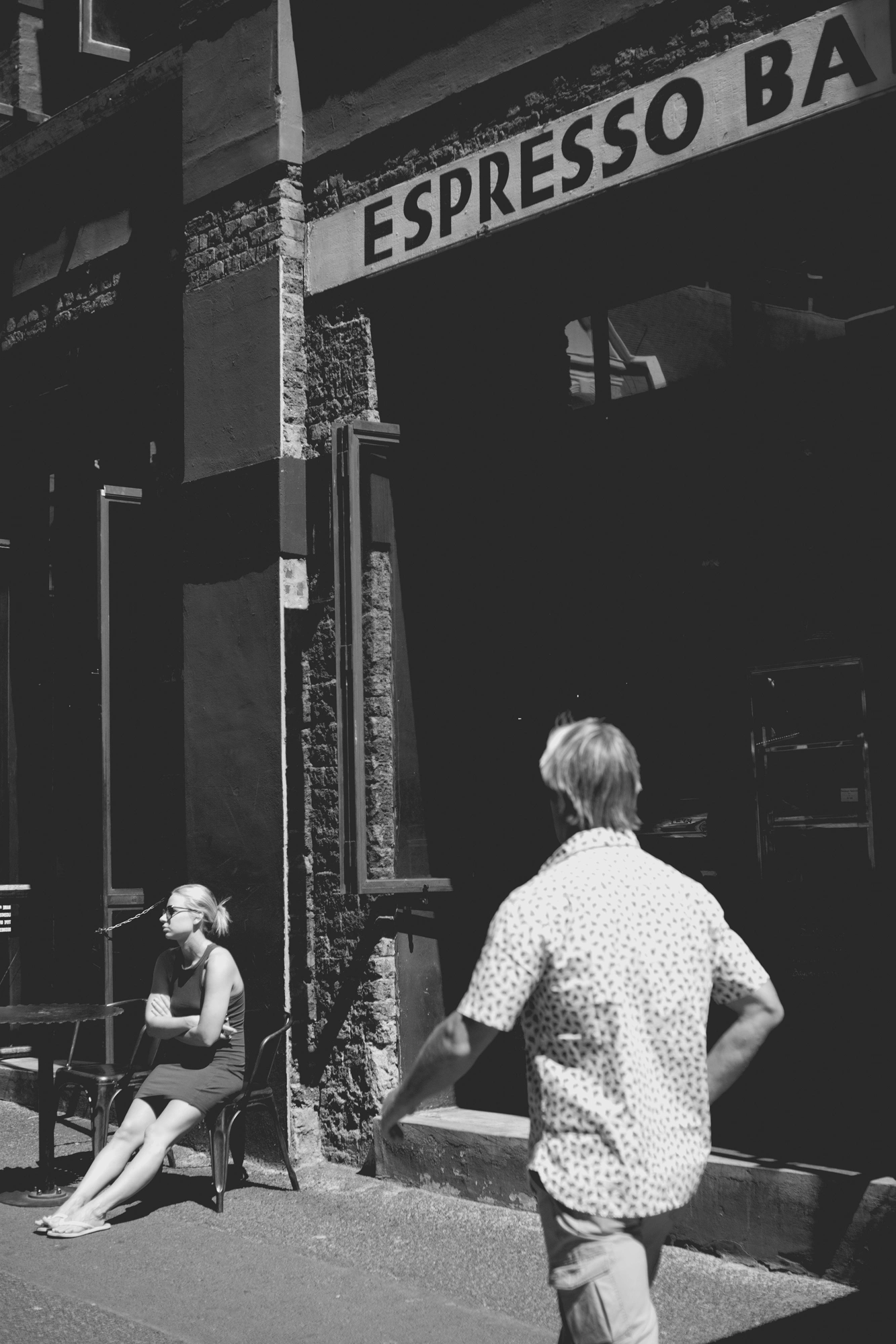 2022-02-17 - xt35 - bw - ZA - Cape Town - Man walks in front of sign that says 'Espresso Bar'