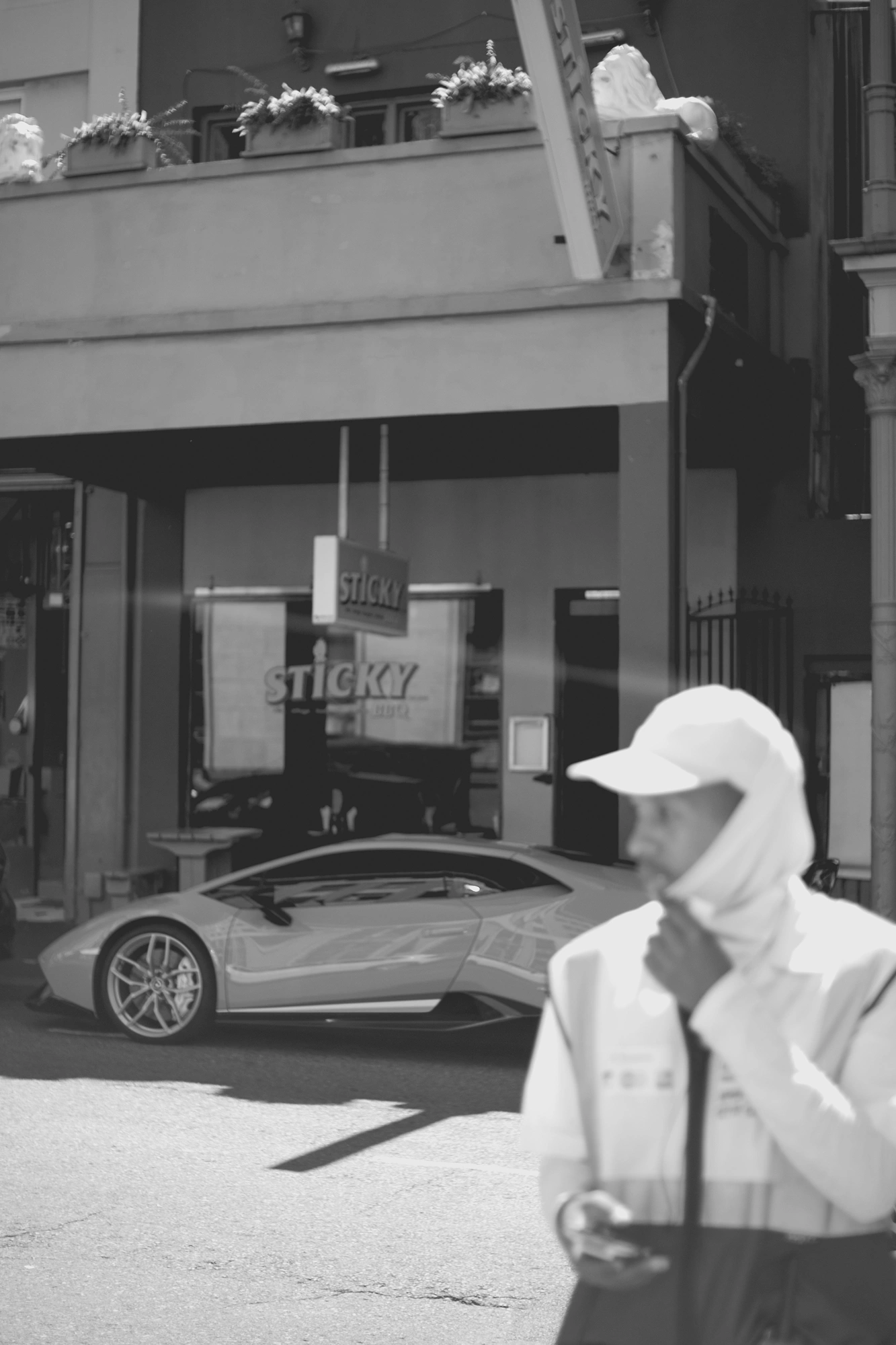 2022-02-17 - xt35 - bw - ZA - Cape Town - Parking gaurd crossing road in front of parked lamborghini