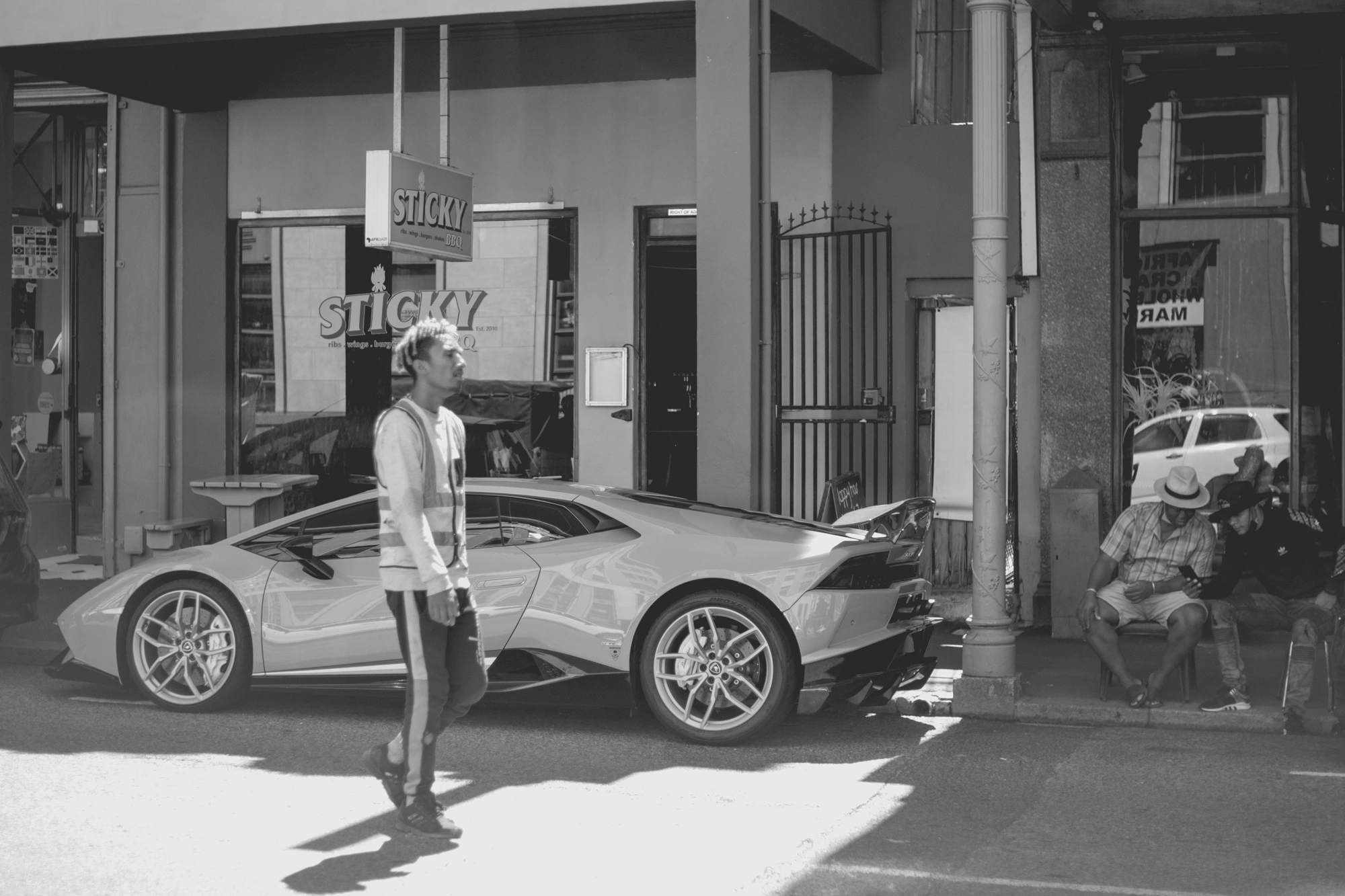2022-02-17 - xt35 - bw - ZA - Cape Town - Person walks in front of parked lamborghini