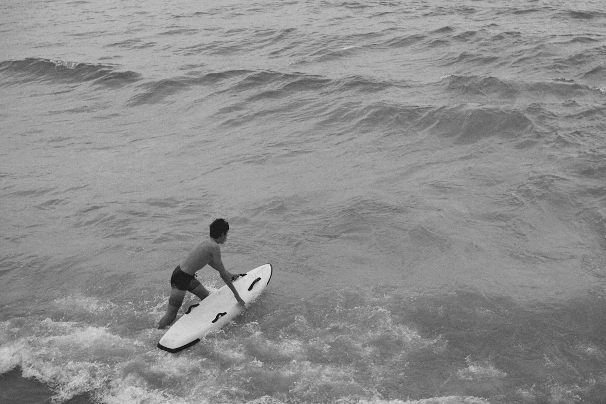 2022-09-18 - xt35 - bw - ZA - Durban - Boy swimming into ocean with surfboard