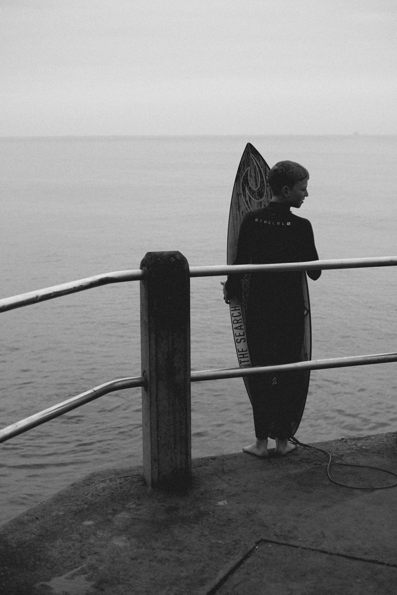 2022-09-18 - xt35 - bw - ZA - Durban - Boy with surfboard