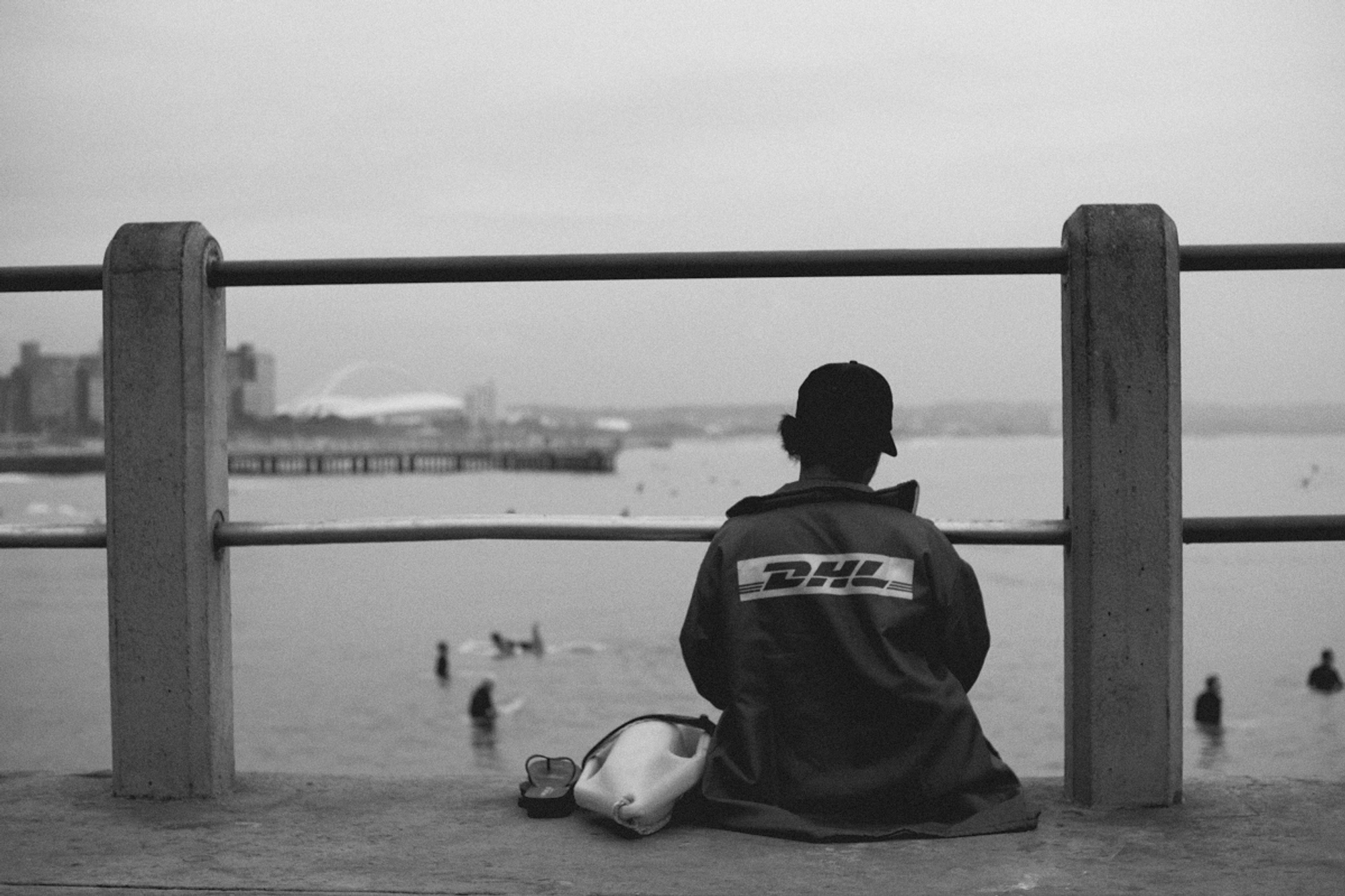 2022-09-18 - xt35 - bw - ZA - Durban - Lifeguard sitting on edge of pier