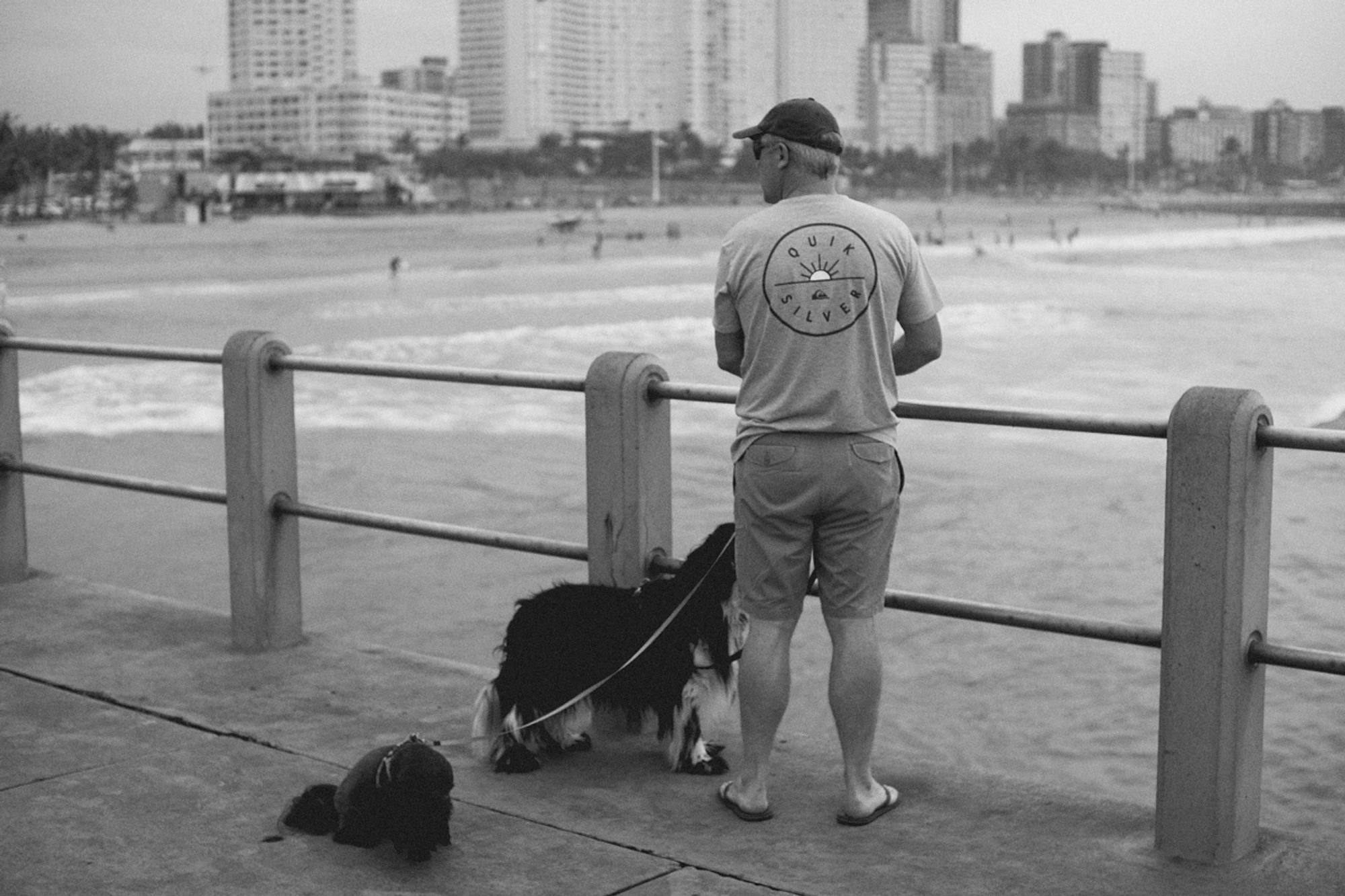 2022-09-18 - xt35 - bw - ZA - Durban - Man on pier with dogs
