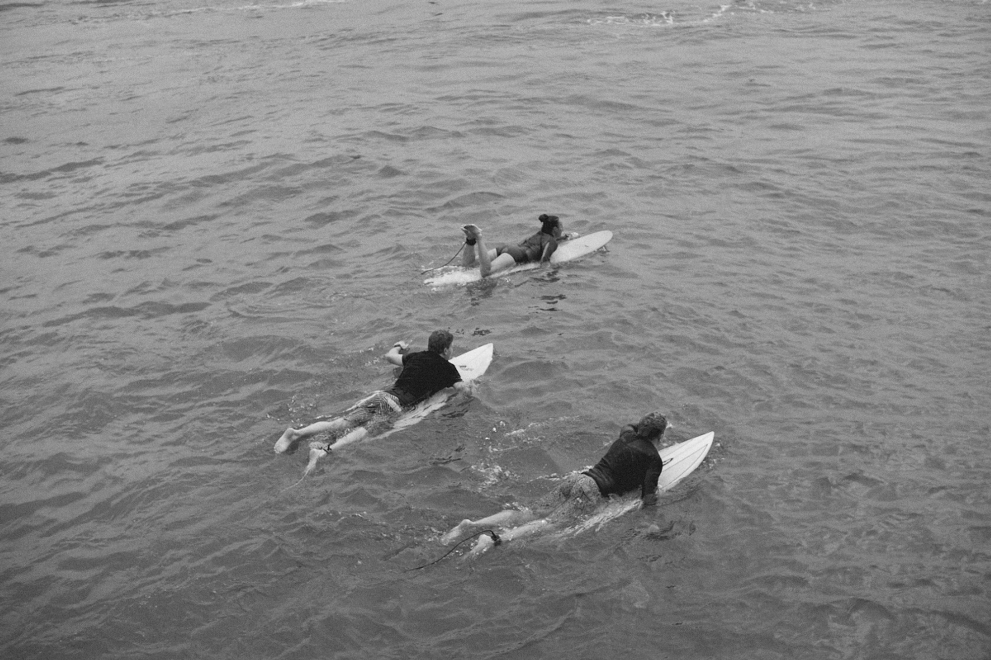 2022-09-18 - xt35 - bw - ZA - Durban - Three people on surfboards swimming out