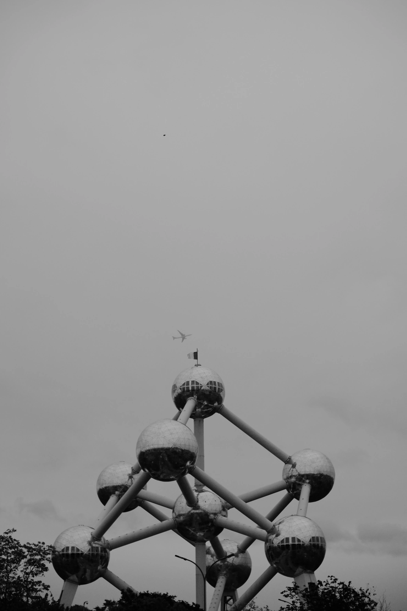 2024-06-15 - xt35 - bw - BE - Brussles - Plane flying on top of atomium