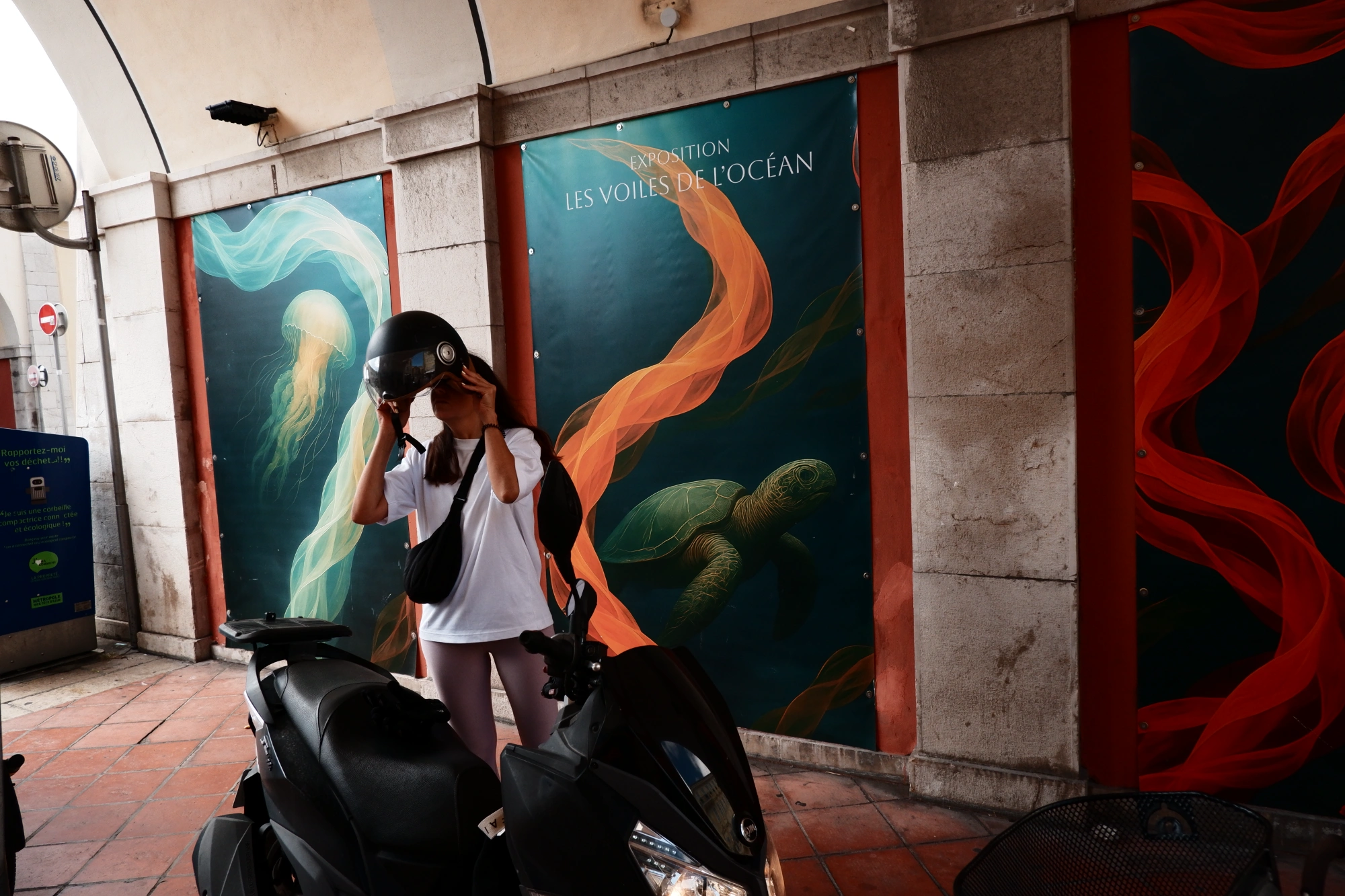 2025-09-06 - xt15-45 - color - FR - Nice - Person putting on scooter helmet