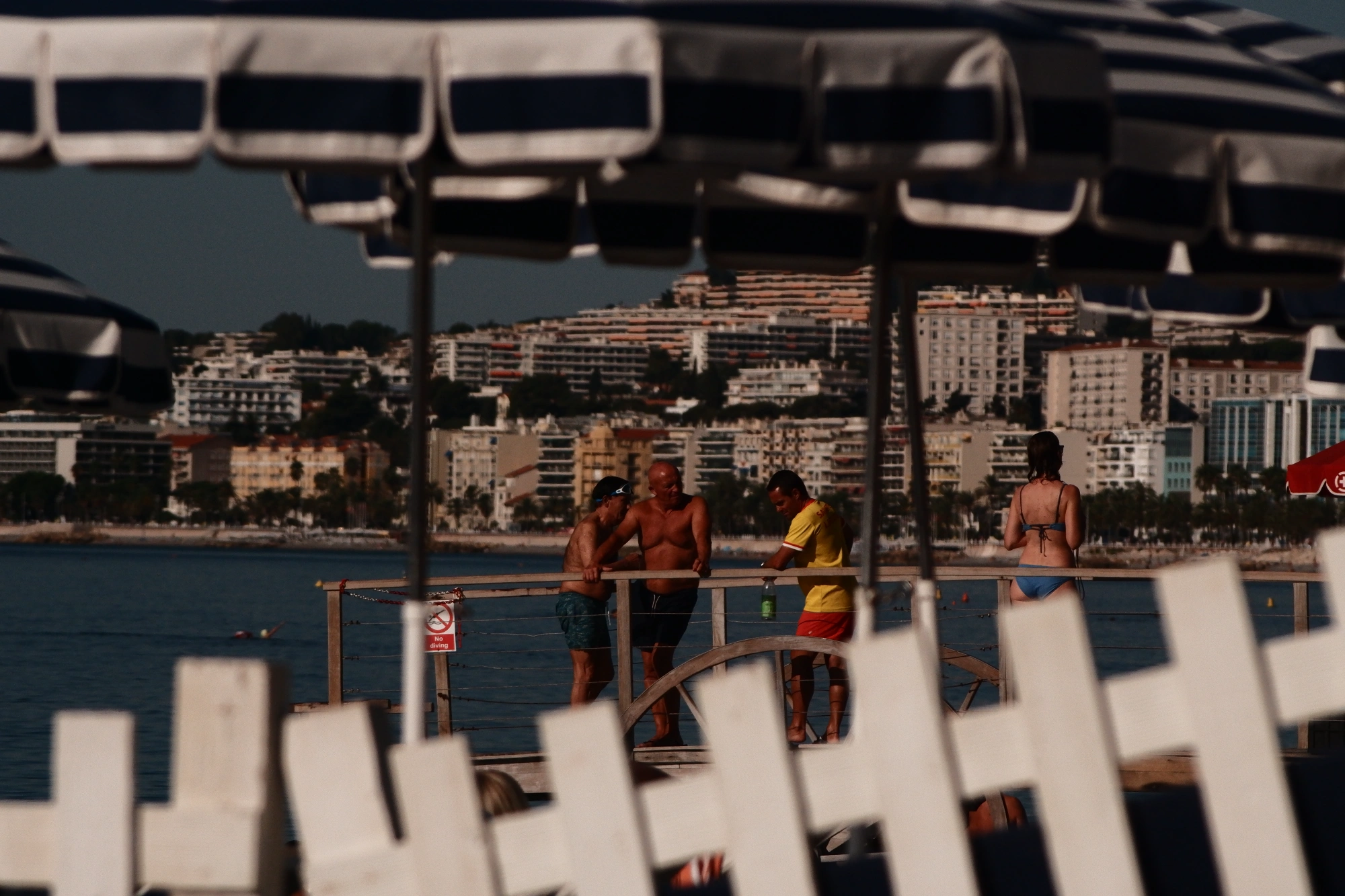 2025-09-07 - xt75-300 - color - FR - Nice - People standing at beach between umbrellas