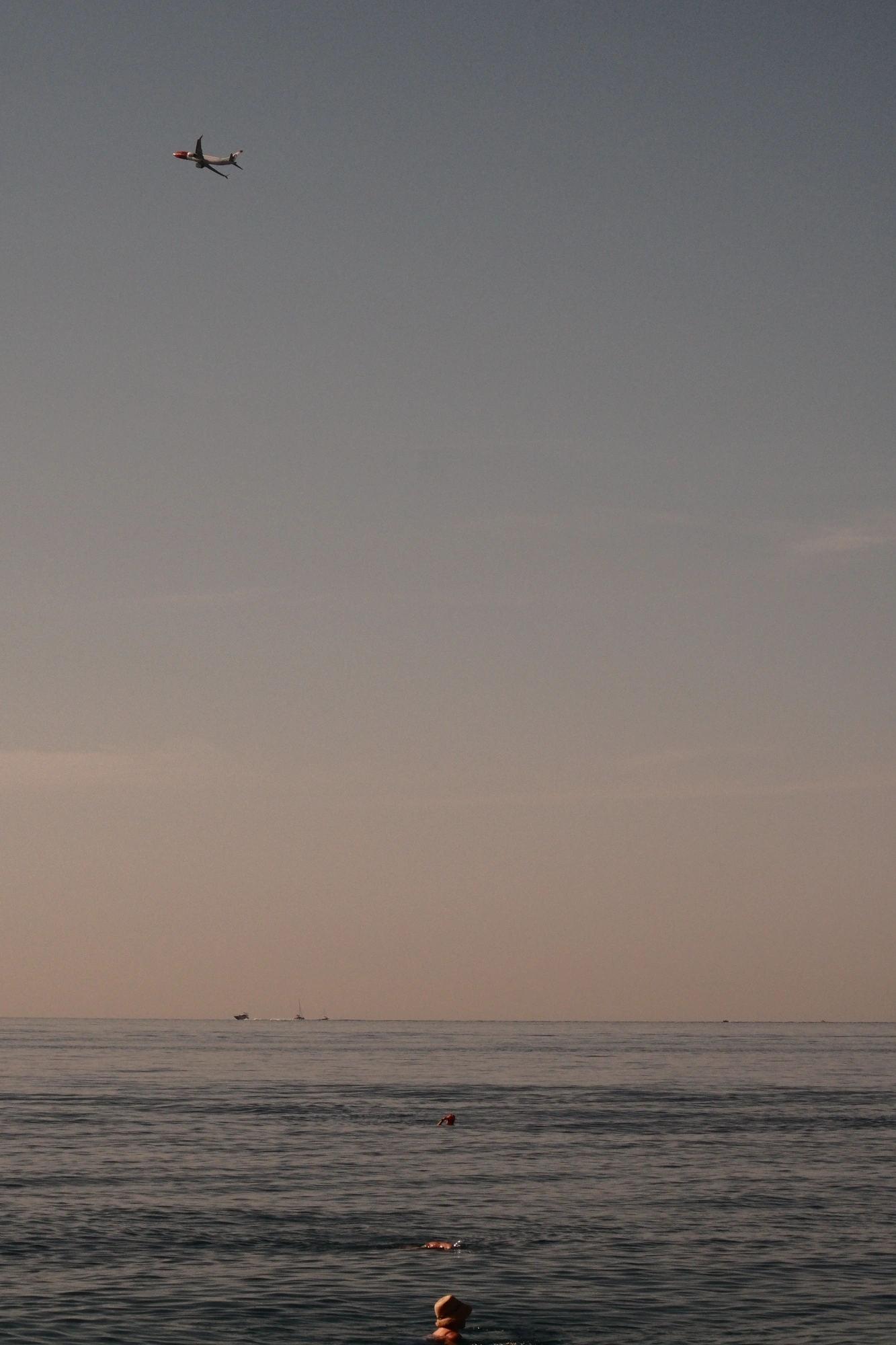 2025-09-07 - xt75-300 - color - FR - Nice - Person in water with plane flying in the distance