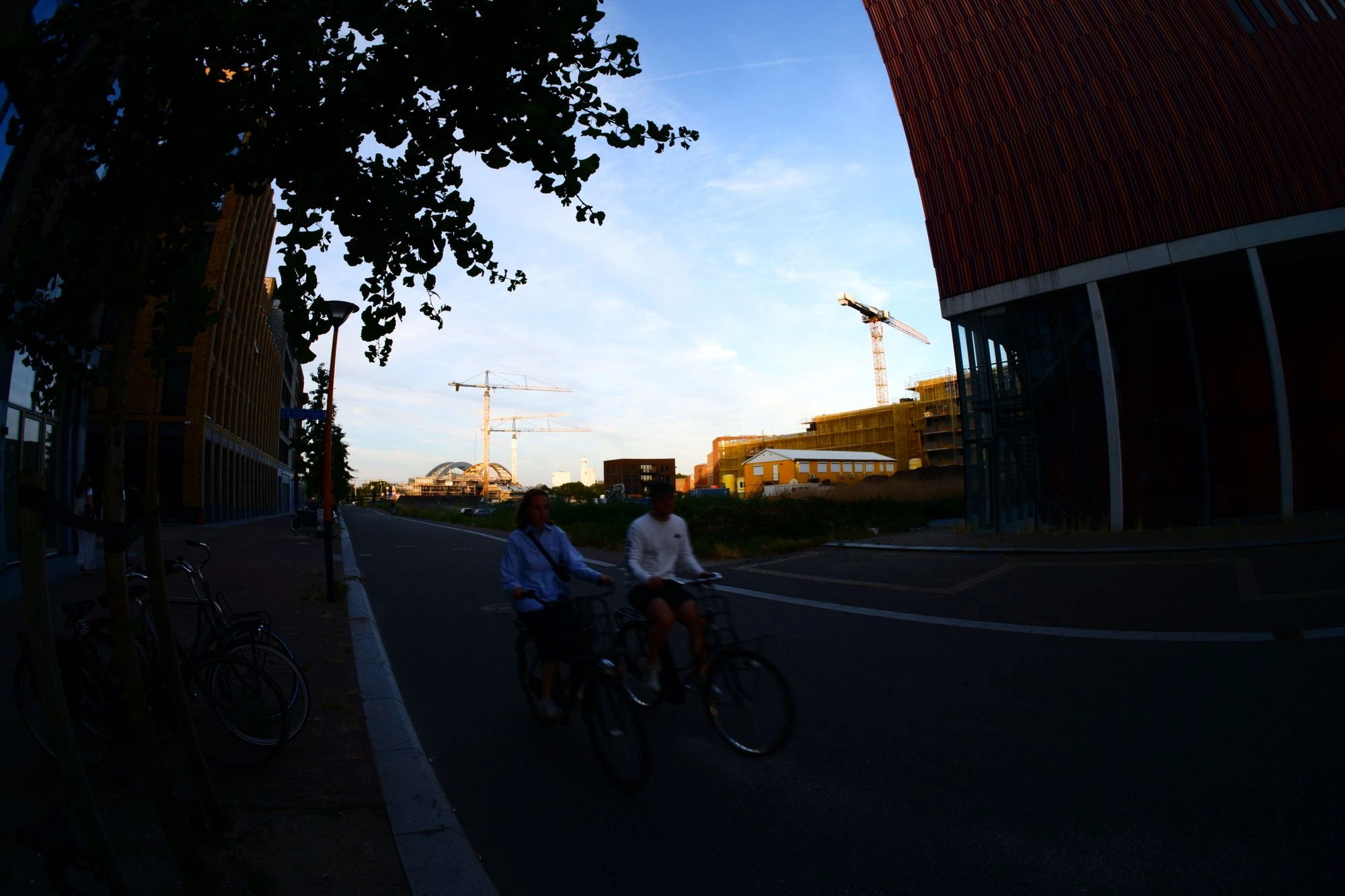 People cycling with construction in the background