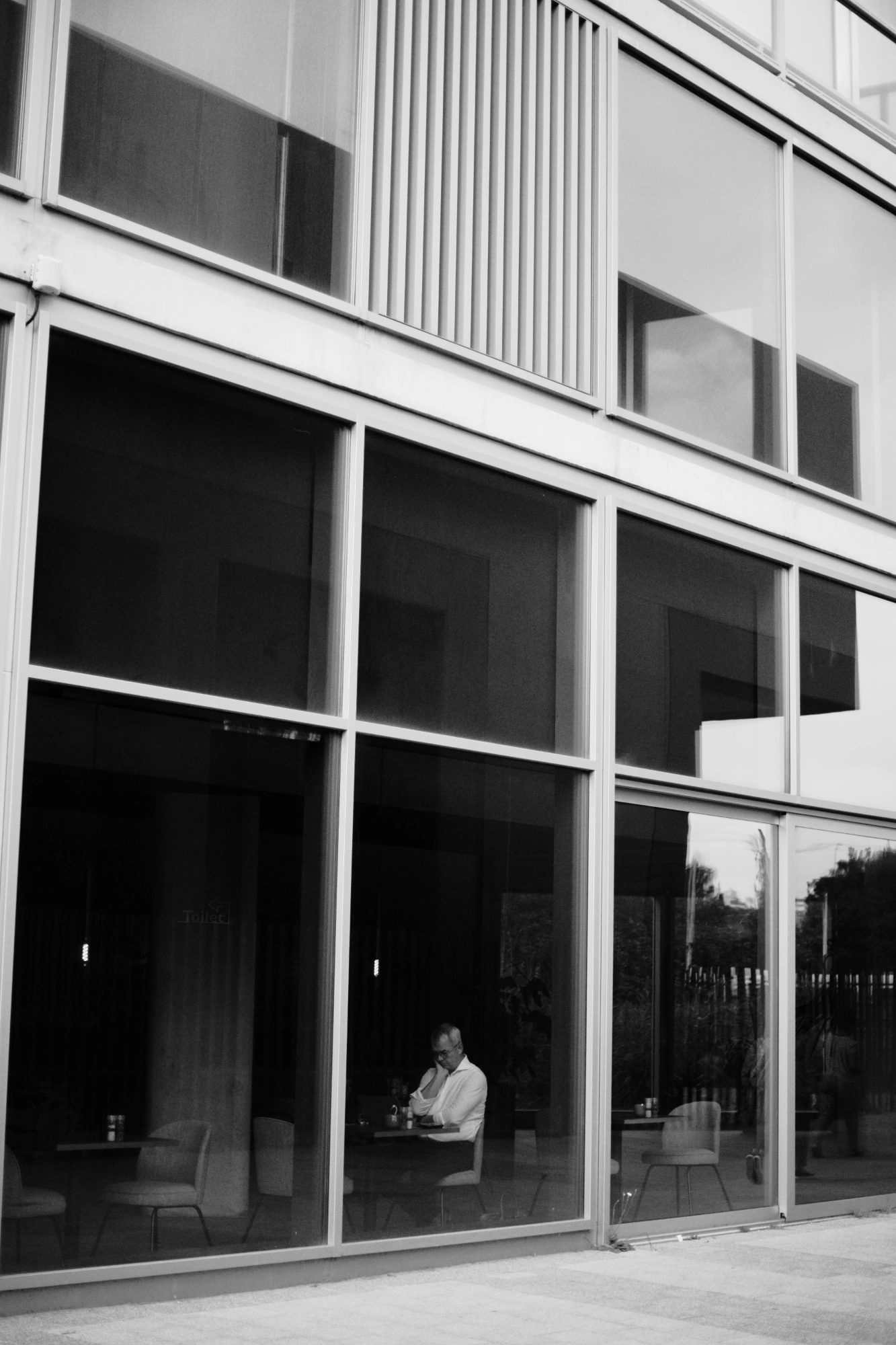 2023-08-25 - xt35 - bw - NL - Building window with person sitting inside