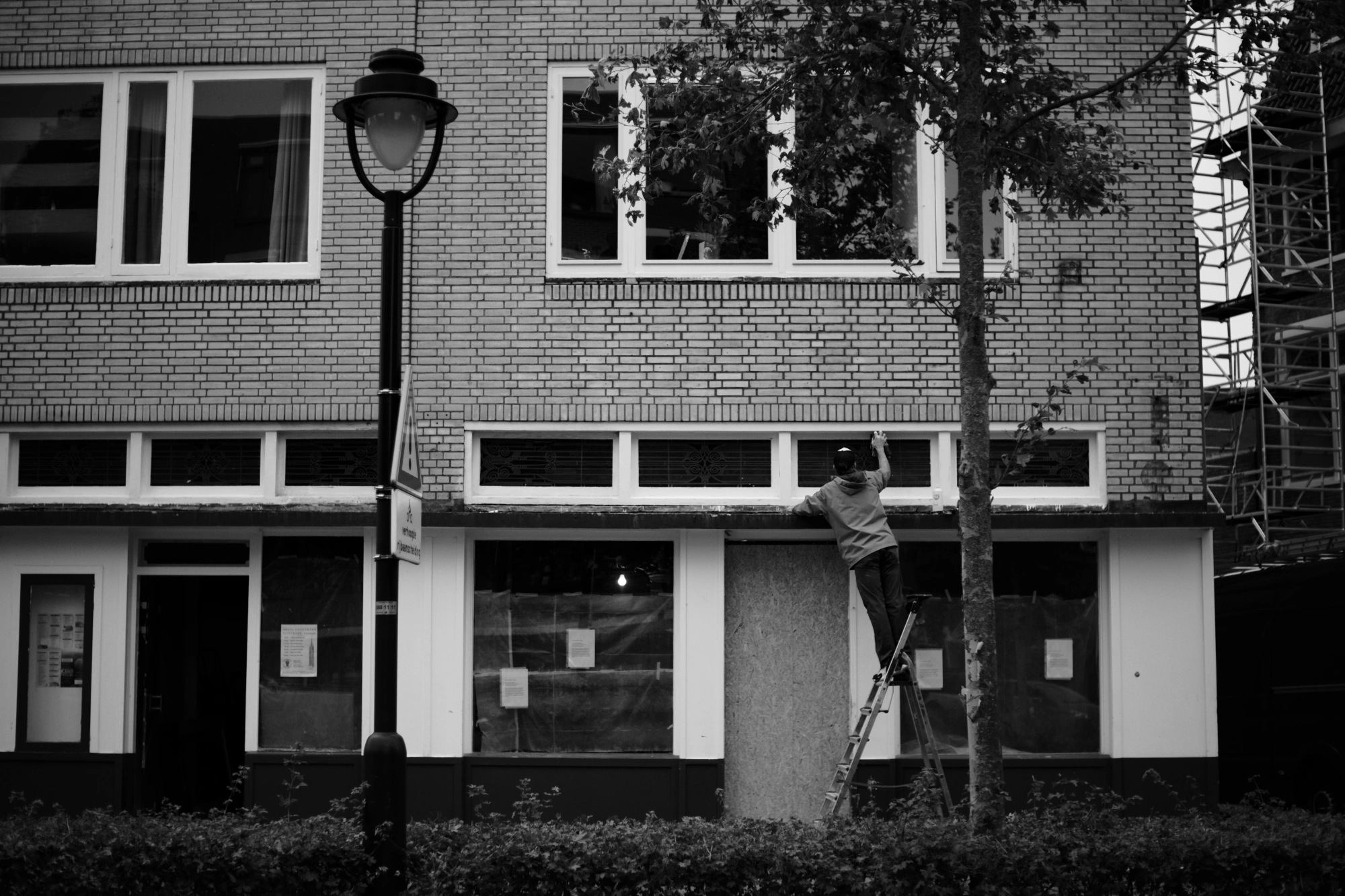 2024-02-03 - xt35 - bw - NL - Person cleaning window