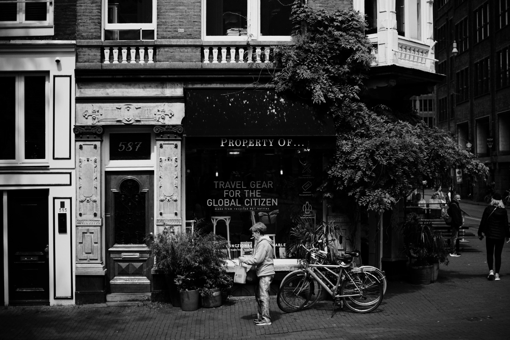 2024-05-25 - xt35 - bw - NL - Person standing outside of store