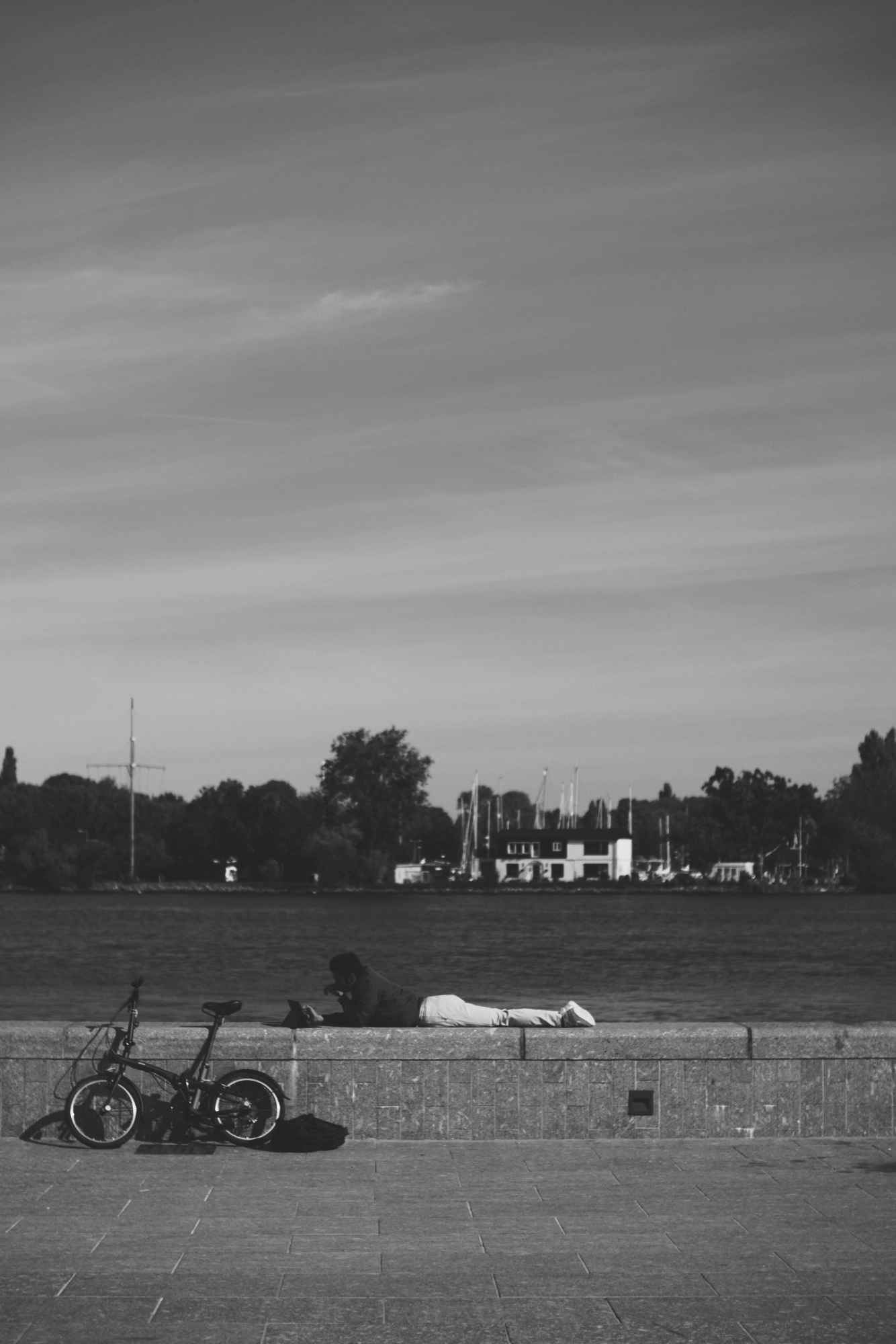 2024-09-27 - xt35 - bw - NL - Amsterdam - Person sitton on wall next to river