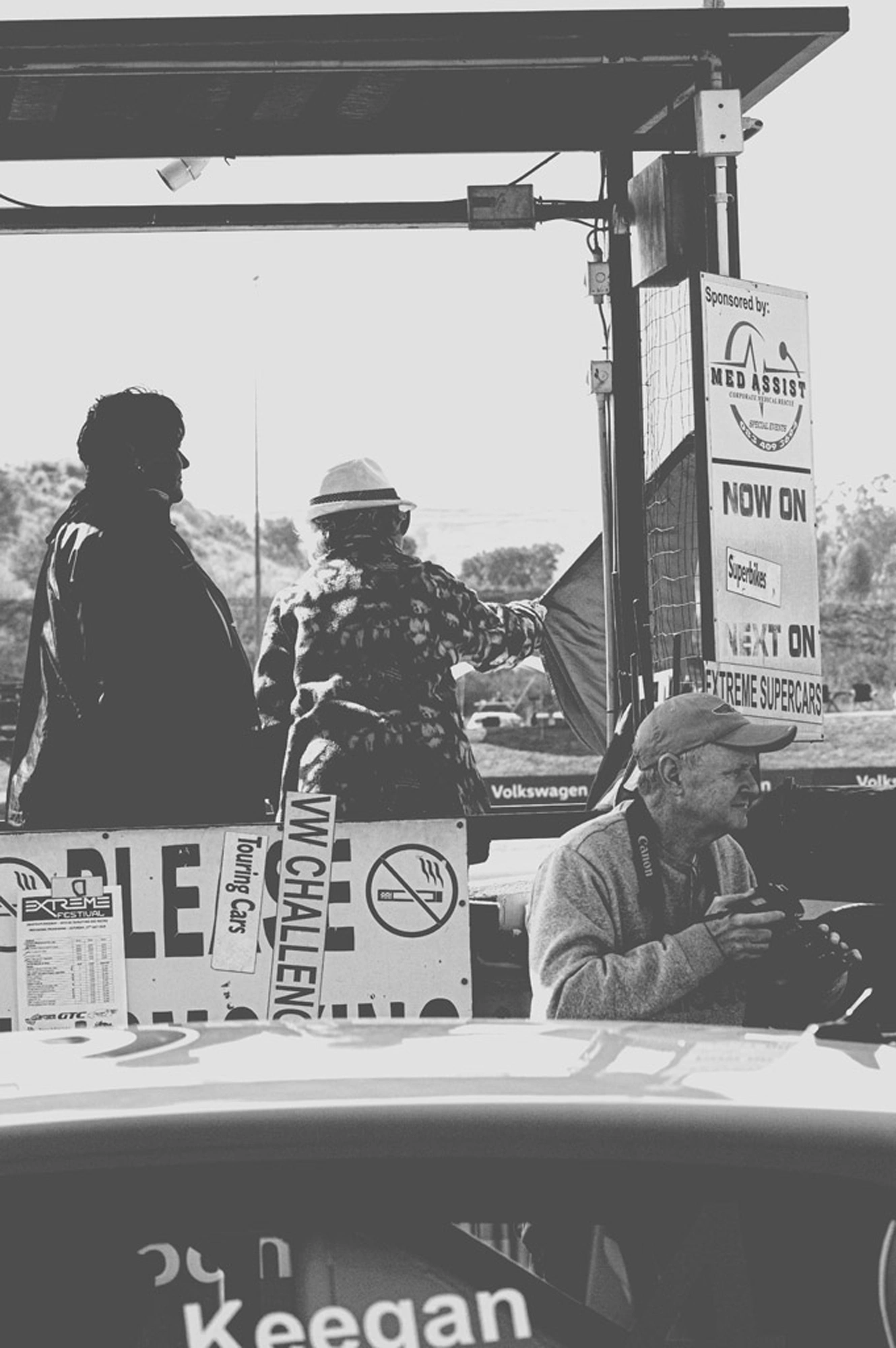 2019-07-27 - n18-55 - bw - ZA - Zwartkops Raceway - Photorapher crossing in front of person waving race flag