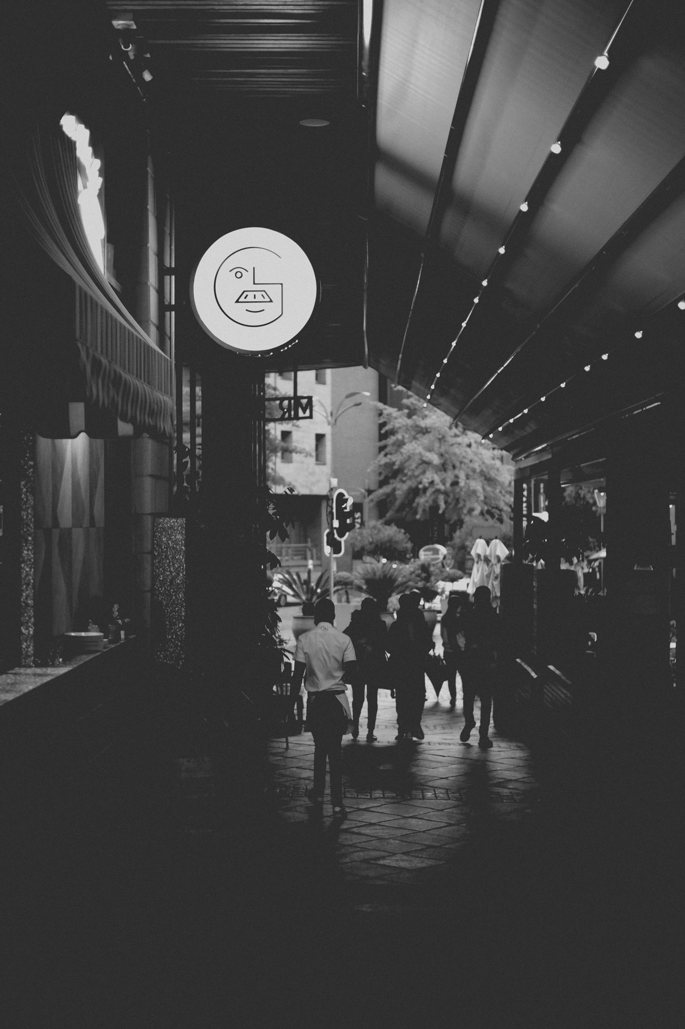 2021-12-04 - xt15-45 - bw - ZA - Melrose Arch, Johannesburg -  People waiting outside of restuarant