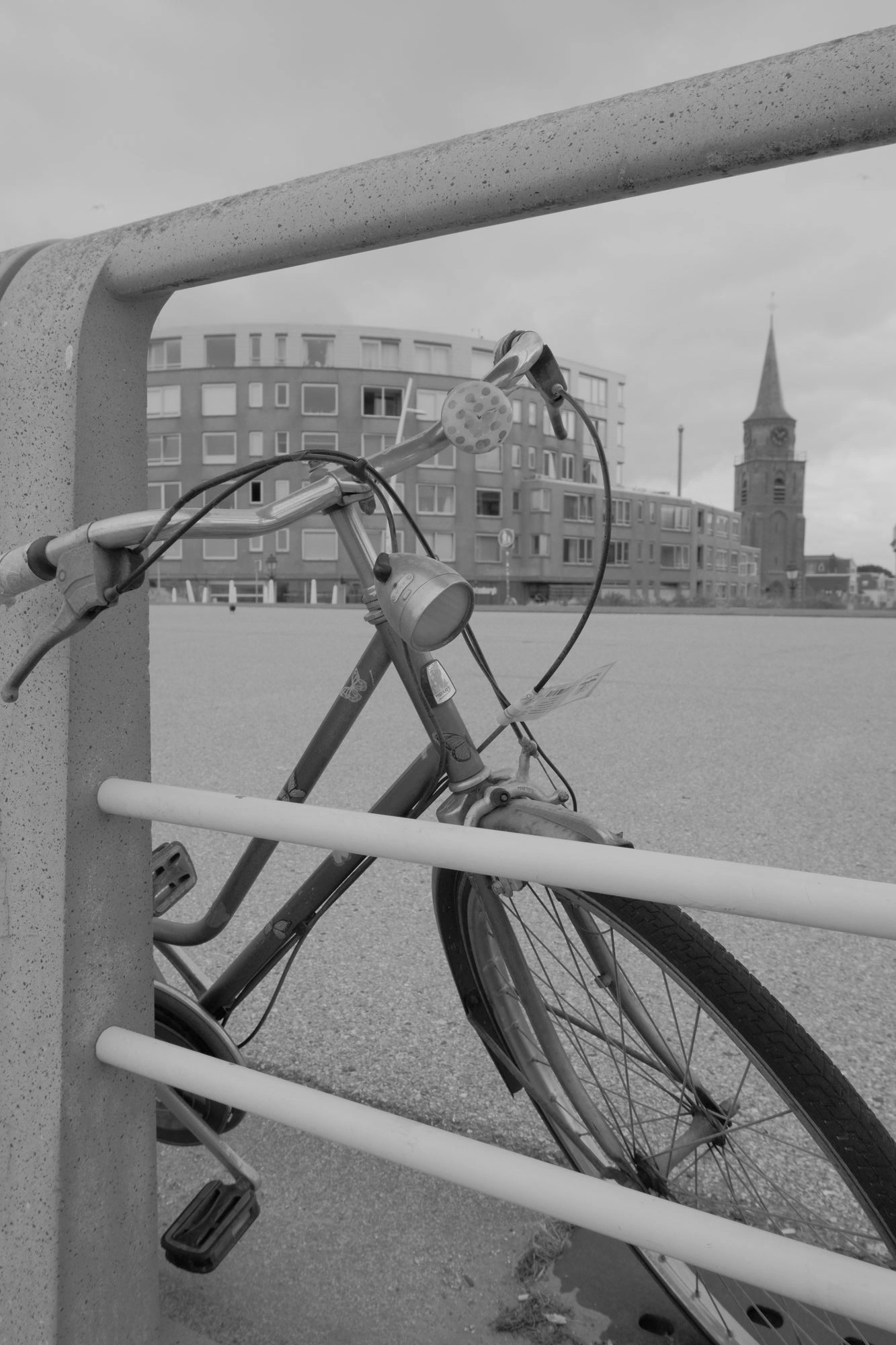 2026-07-18 - Scheveningen - Bike parked next to fence with church in background.J