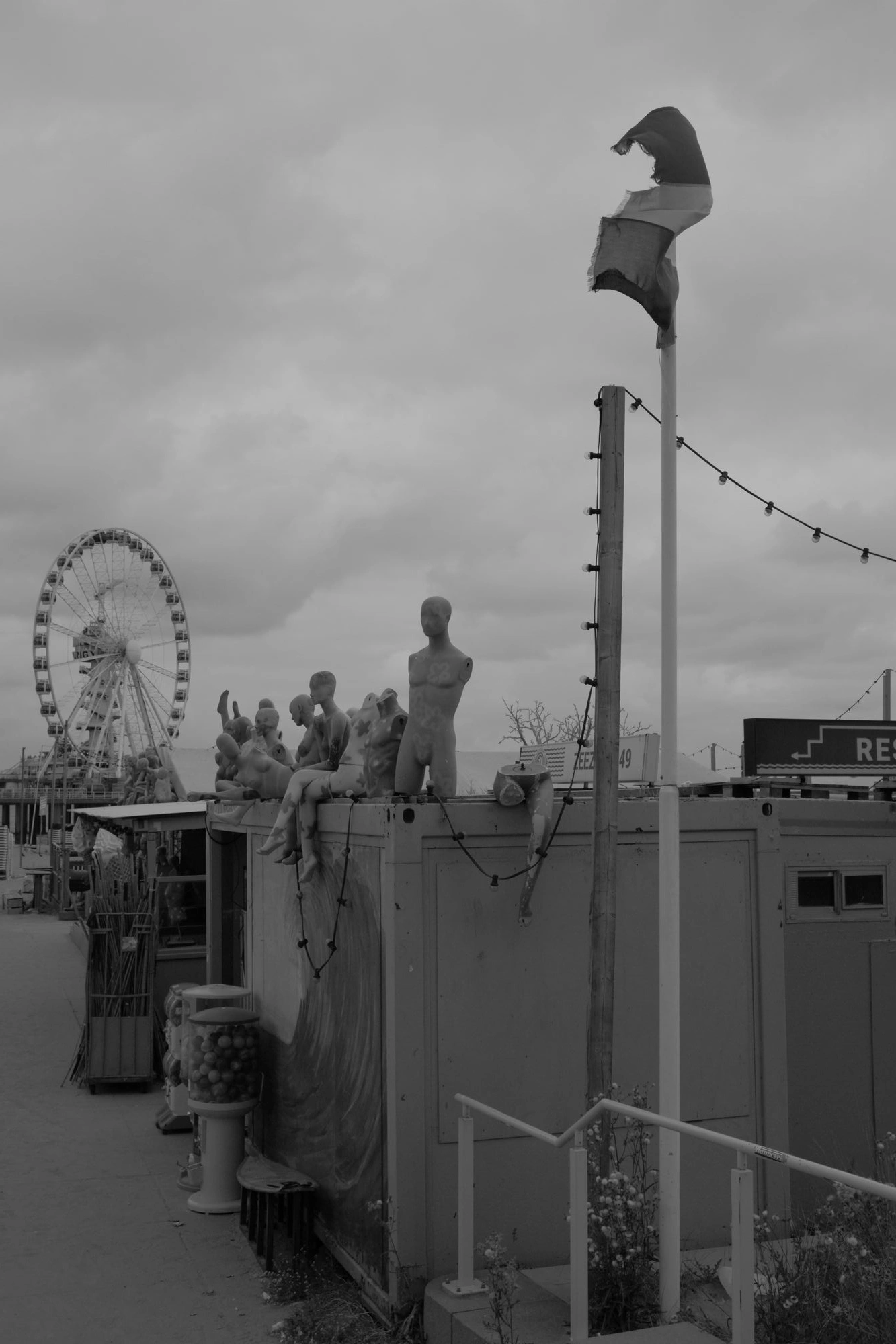 2026-07-18 - Scheveningen - Creepy manequins on top of building with ferris wheel in background.J