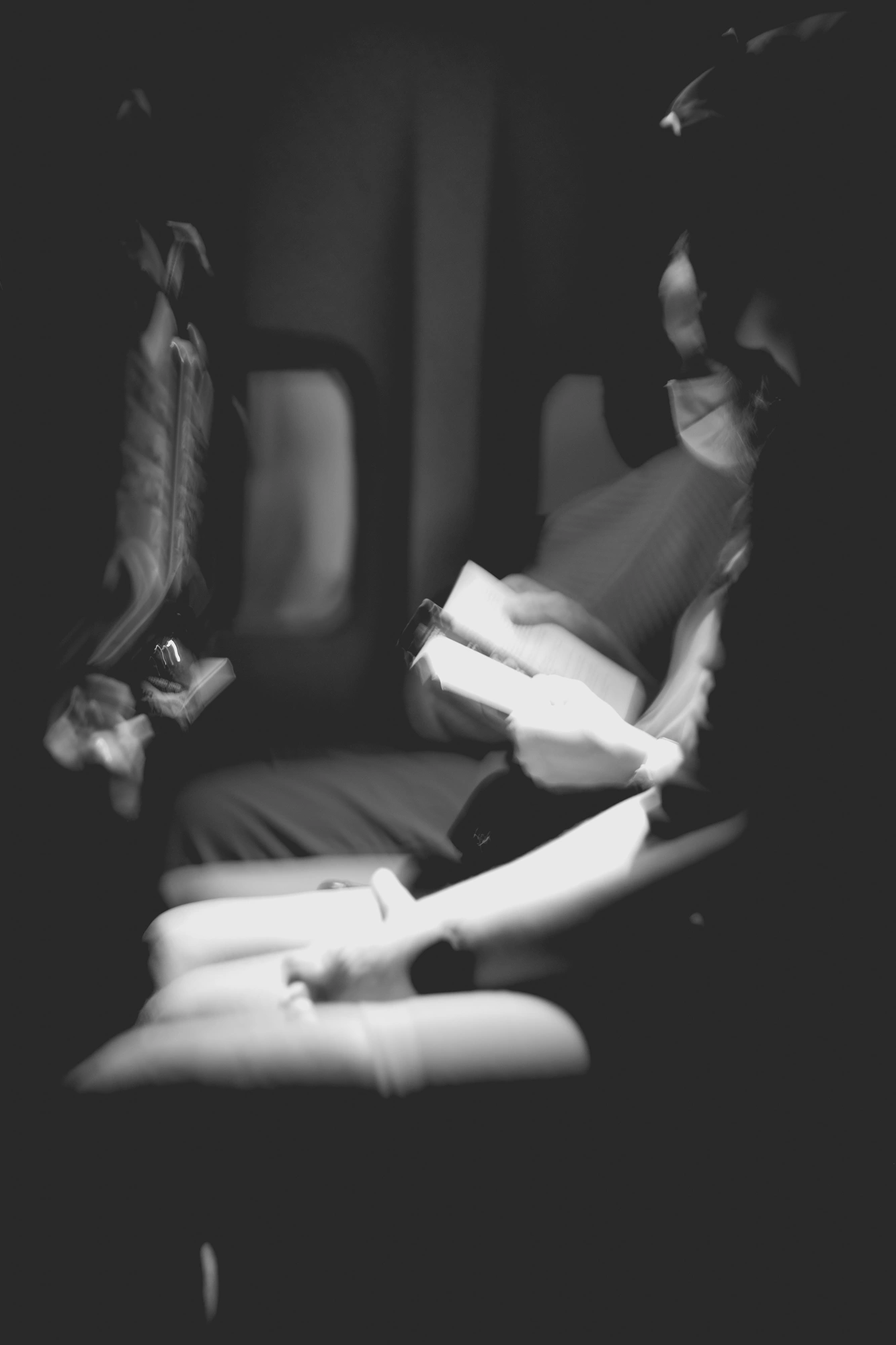 2022-02-18 - Cape Town - Person reads book in the dark on airplane.j