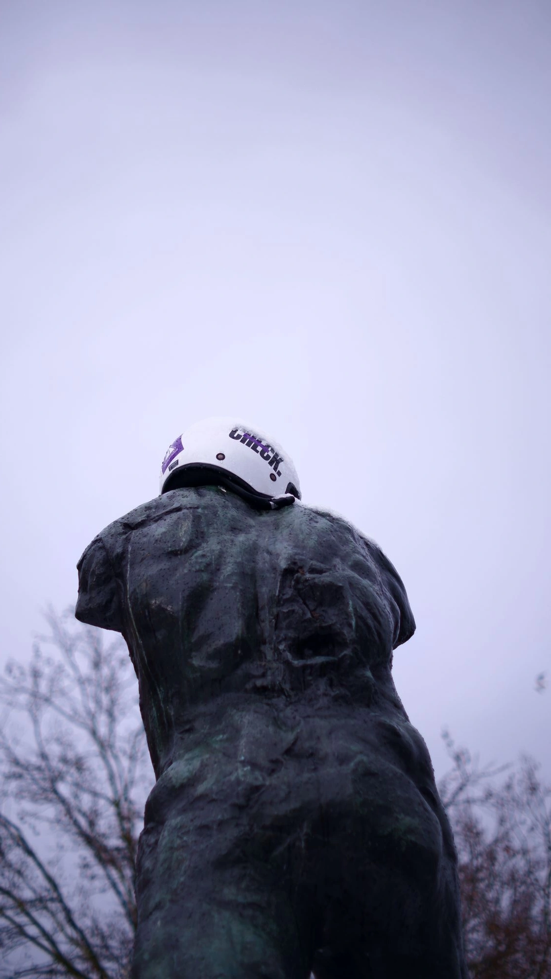 Bike helmet on an armless statue.J