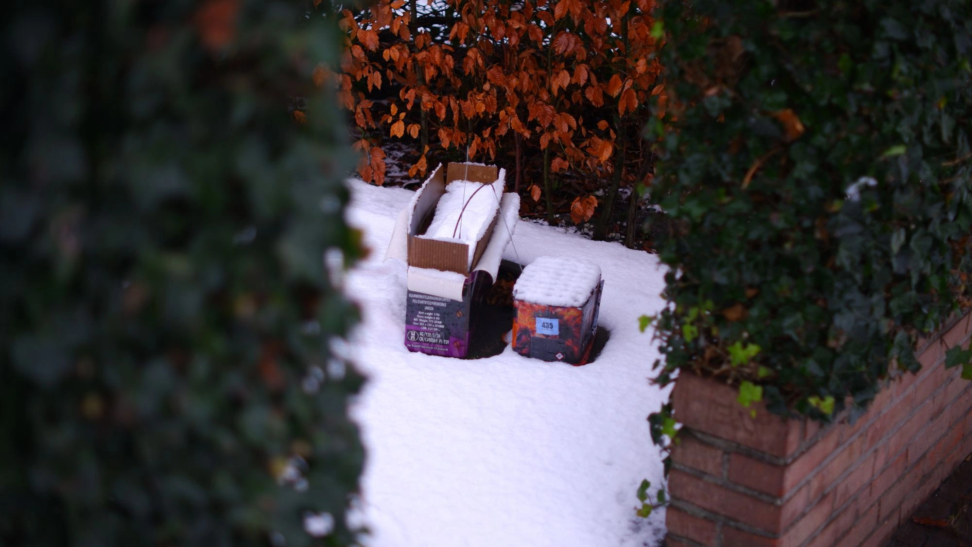 Boxes of fireworks sitting out in the snow.J