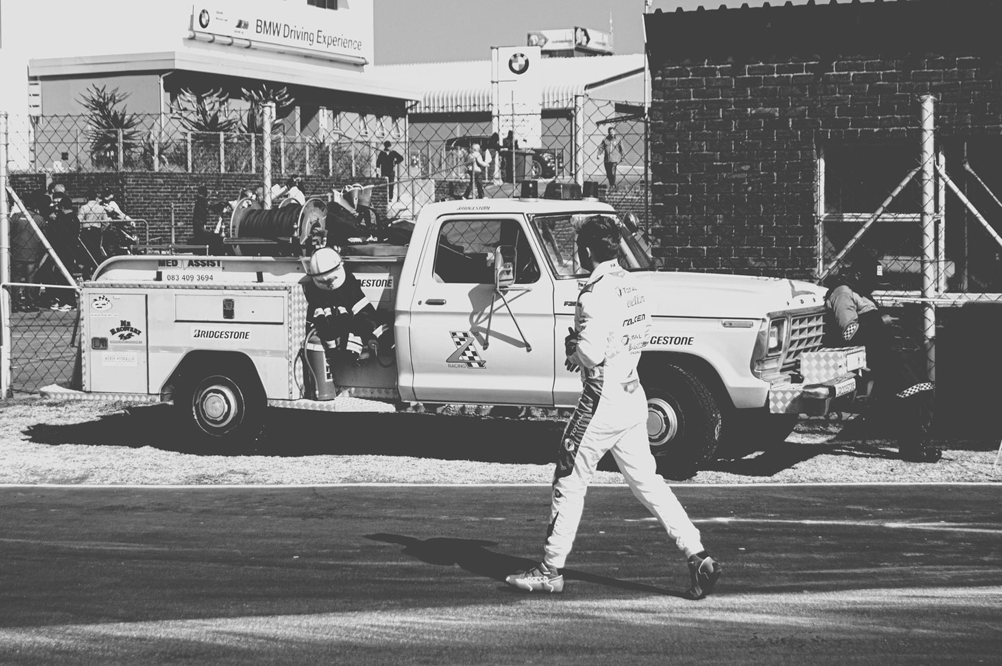 2019-07-27 - Zwartkops Raceway - Driver walks across track with tow truck in the background.j